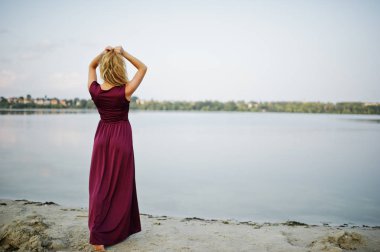 Kırmızı marsala elbise posin sarışın şehvetli yalınayak kadın geri