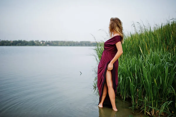 L suda duran kırmızı marsala elbise sarışın şehvetli kadın — Stok fotoğraf