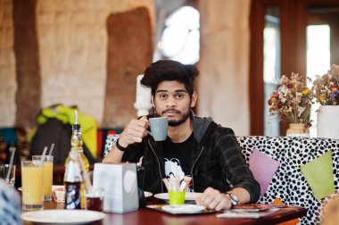Rahat giyim sakal asyalı adam kapalı kafe ve içki cof oturan