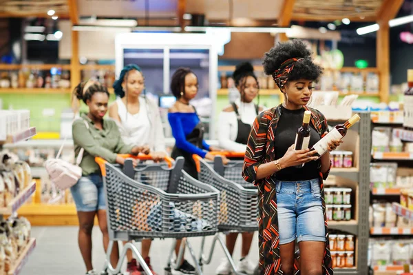 Africká americká žena si vybere víno v supermarketu proti jejímu zlu — Stock fotografie