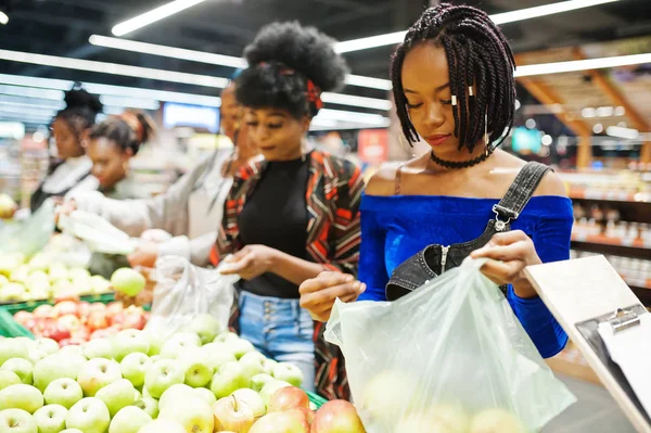 Група з п'яти африканських жінок, які збирають яблука в пластикових пакетах — стокове фото