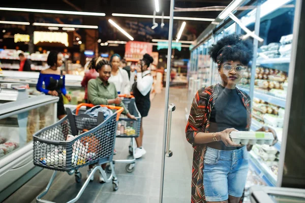 Group of african womans with shopping carts near refrigerator sh — Stock Photo, Image