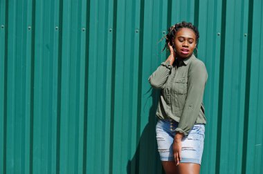 Dreads saç ile Afrikalı kadın, kot şort gr karşı poz