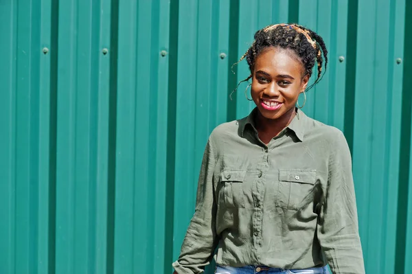 Mujer africana con rastas en el pelo, en pantalones cortos de jeans posados contra gr — Foto de Stock