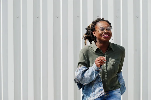 Mujer africana con rastas en el pelo, en jeans chaqueta y pantalones cortos, llevar — Foto de Stock