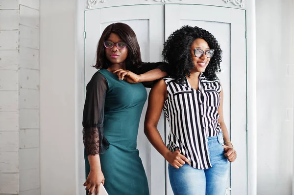 Duas amigas africanas usam óculos posados em branco interior — Fotografia de Stock