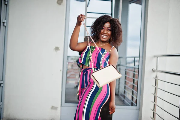 Modieuze Afro-Amerikaanse vrouw in roze gestreepte jumpsuit, wit — Stockfoto