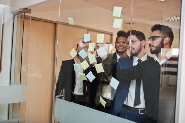 Renkli kağıt notalarla camı işaret eden iş adamları. Dalgıç