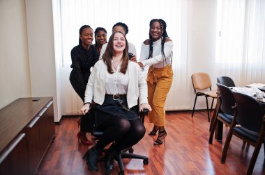 Beş çok ırklı iş kadını ofiste ayakta ve rulo wom