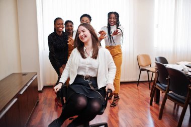 Beş çok ırklı iş kadını ofiste ayakta ve rulo wom