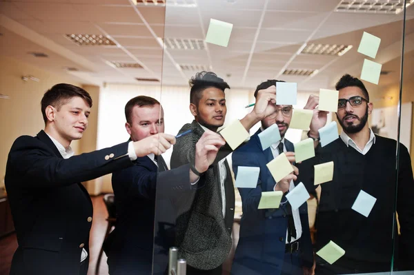 Renkli kağıt notalarla camı işaret eden iş adamları. Dalgıç