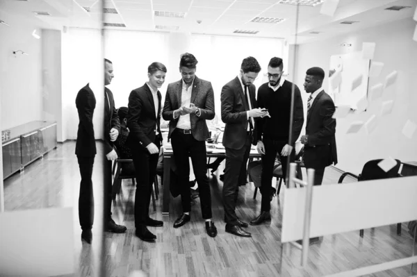 Six multiracial business mans standing at office and use mobile