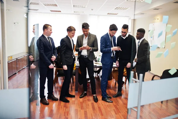 Sechs multiethnische Geschäftsleute stehen im Büro und nutzen Mobiltelefone — Stockfoto