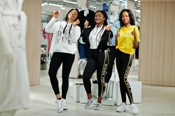 Three afican american women in tracksuits shopping and show thum