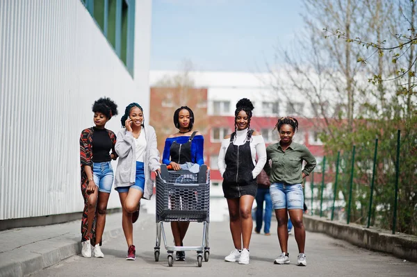 En grupp på fem afroamerikanska kvinnor med kundvagnar som — Stockfoto