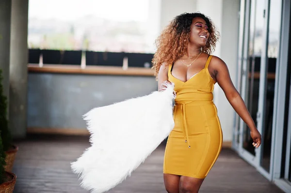 Glamour mujer afroamericana en vestido amarillo y lana blanca — Foto de Stock