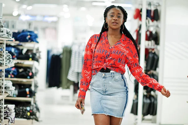 Modish african american woman in  red shirt and jeans skirt pose