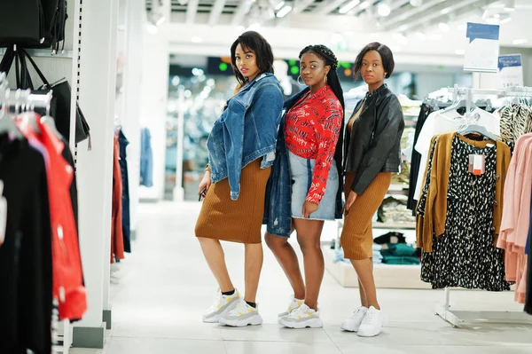 Three attractive african american woman in brown tunic dress pos