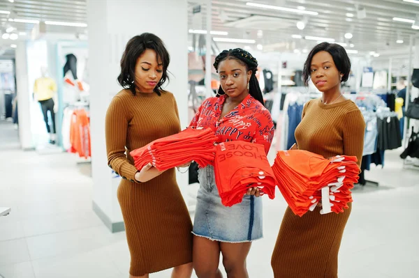 Three attractive african american woman in brown tunic dress pos