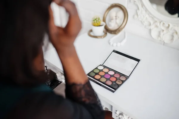 Mujer afroamericana bonita con paleta de maquillaje en las manos . — Foto de Stock