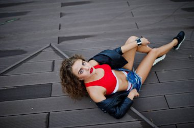 Kırmızı üst seksi kıvırcık model kız, kot kot şort, deri ja