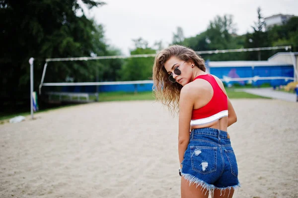 Sexy curly modelo menina em top vermelho, calça jeans jeans, copo e su — Fotografia de Stock