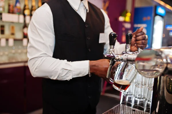 Close up hands of african american bartender at bar pouring from