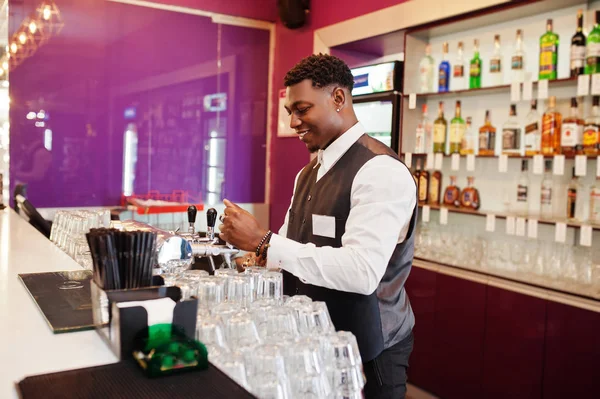 African American Bartender w barze nalewanie z kranu świeżego piwa w — Zdjęcie stockowe