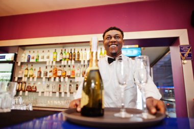 Barda gözlüklü şampanya tutan Afro-amerikan barmen