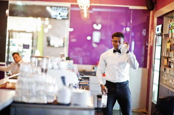 African american bartender at bar flair in action, working behin