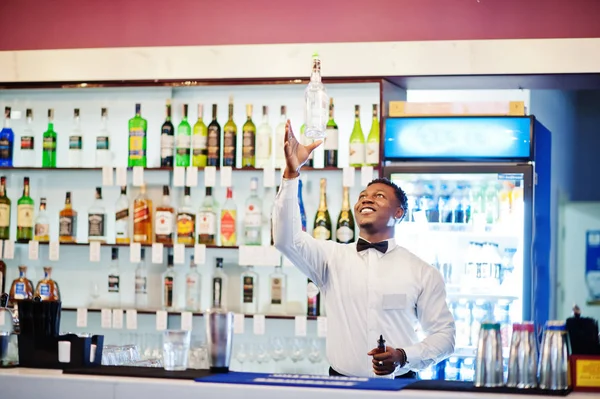 African american bartender at bar flair in action, working behin