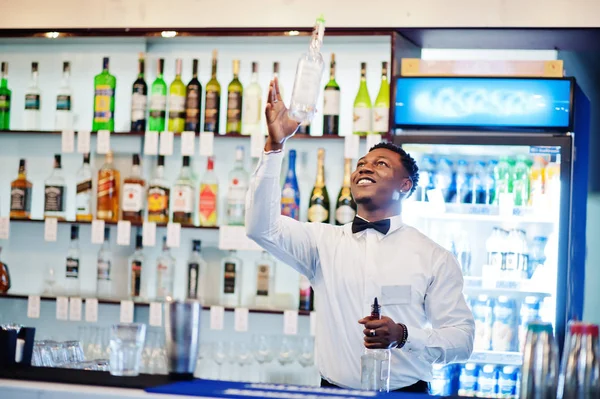 African american bartender at bar flair in action, working behin