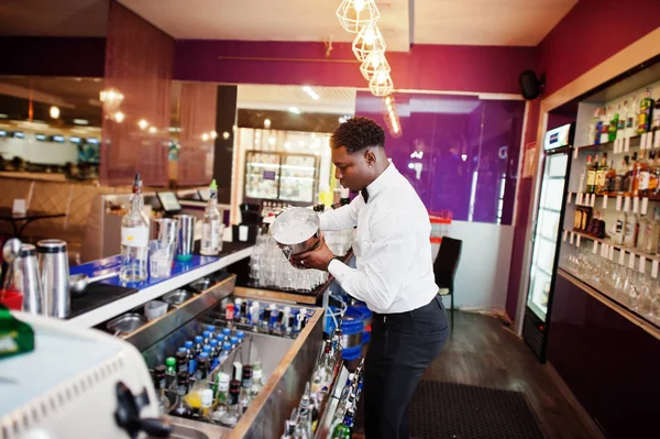 African american bartender at bar with ice bucket. Alcoholic bev