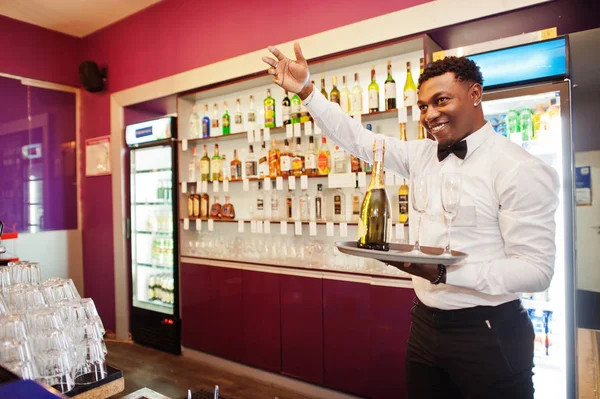 African American Bartender w barze trzymania szampana w okularach — Zdjęcie stockowe