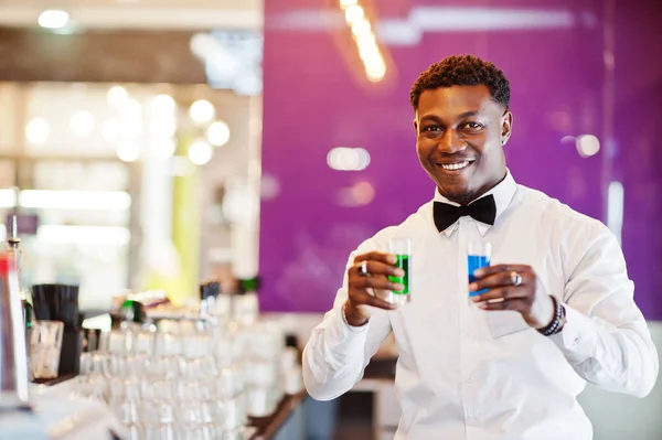 African American Bartender w barze trzyma dwa koktajl strzałów. Alc — Zdjęcie stockowe