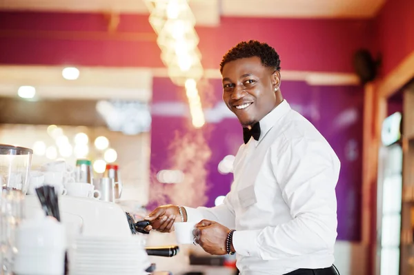 African american bartender barista at bar preparing coffee.