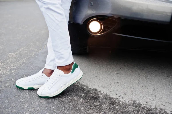 Közelről cipők afrikai férfi fehér nadrág ellen autó. — Stock Fotó