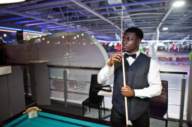 Beyaz gömlek, siyah yelek giyen yakışıklı bir Afrikalı.