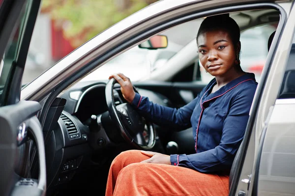 Wanita kaya afrika duduk di kursi pengemudi di mobil mewah perak — Stok Foto