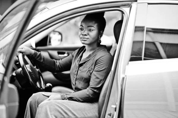 Rich business african woman sit on driver seat at silver suv car