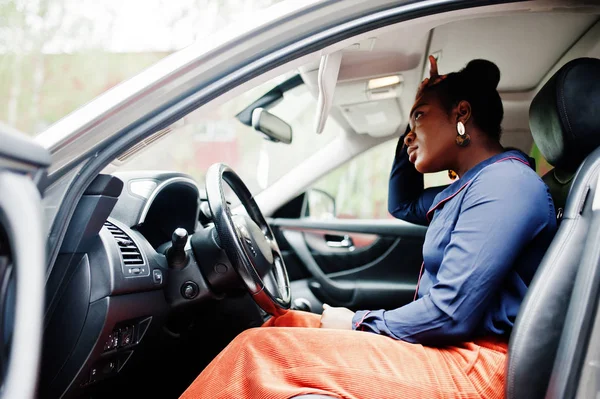 Багата ділова африканка сидить на водійському сидінні на срібному автомобілі — стокове фото