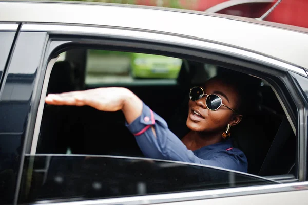 Rico negócio mulher africana em óculos de sol sentar-se no carro suv e sho — Fotografia de Stock