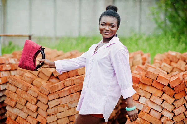 Wanita Afrika berbaju merah muda besar berpose terhadap batu bata . — Stok Foto