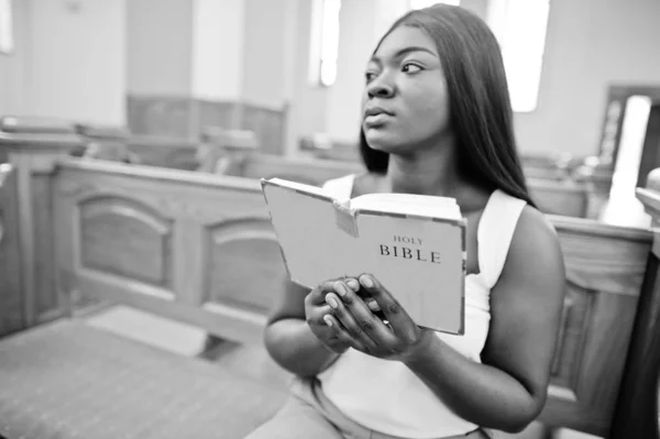 Mujer afroamericana rezando en la iglesia. Los creyentes meditan — Foto de Stock