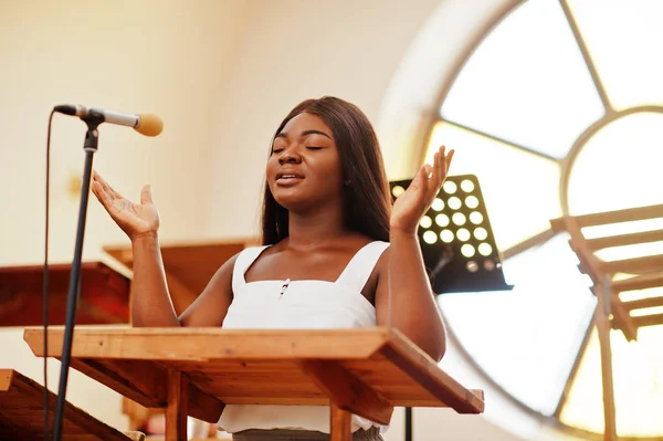 Mujer afroamericana rezando en la iglesia. Los creyentes meditan — Foto de Stock