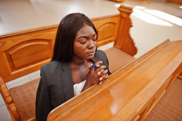 Afro-Amerikalı kadın kilisede dua ediyor. Müminler meditasyon
