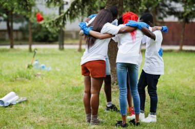 Mutlu Afrikalı gönüllüler grubu parkta kucaklaşıyor. Afrika gönüllü