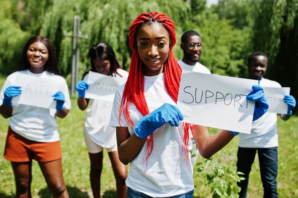 Ομάδα από χαρούμενους Αφρικανούς εθελοντές κατέχουν κενή σανίδα με υποστήριξη — Φωτογραφία Αρχείου