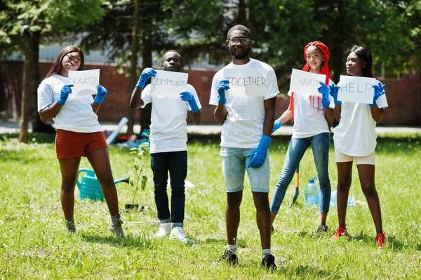 Csoport boldog afrikai önkéntesek tart üres tábla együtt — Stock Fotó