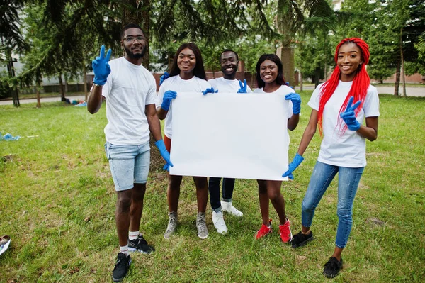 Kelompok relawan afrika bahagia memegang kosong papan di taman — Stok Foto